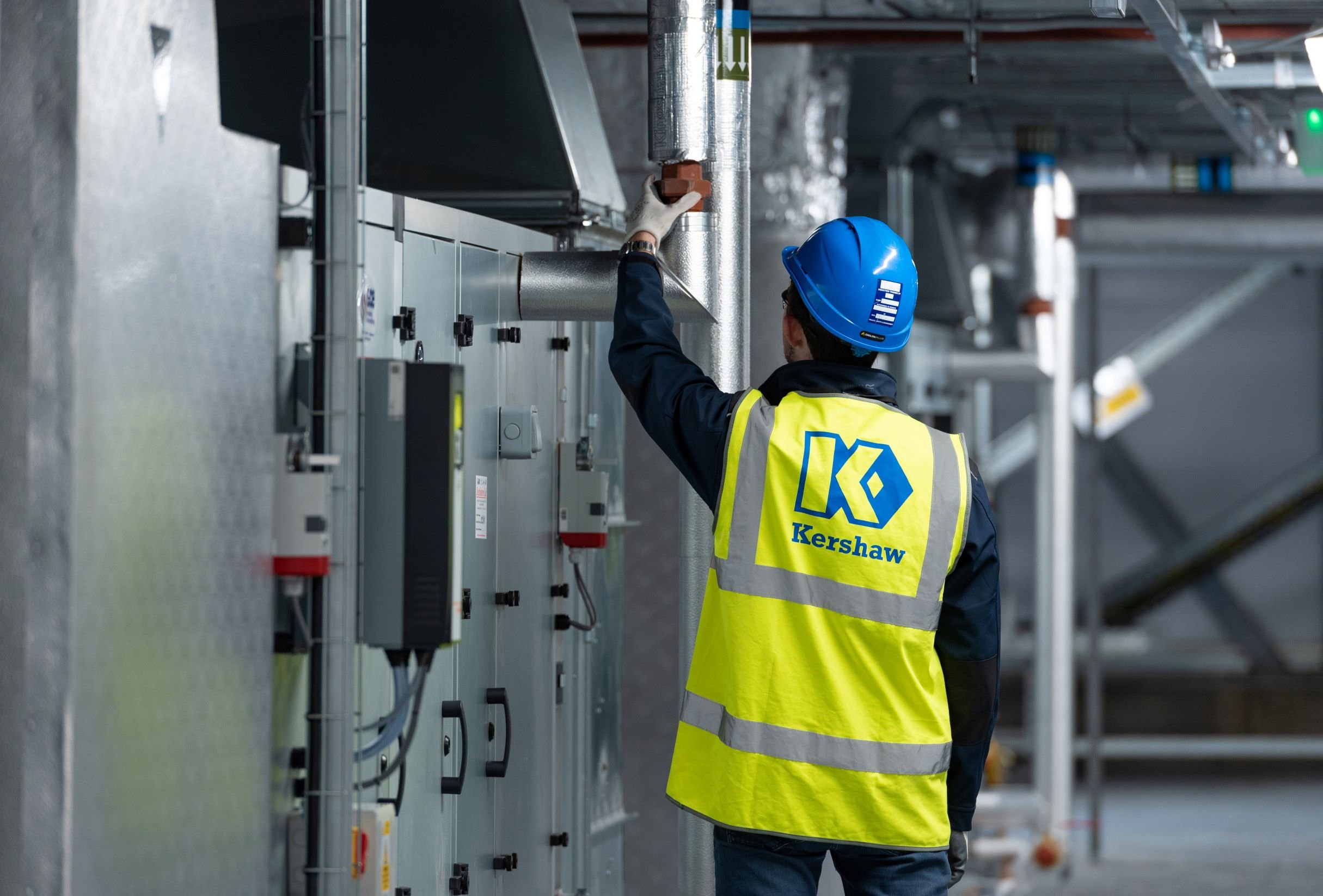 Building maintenance engineer wearing Kershaw Mechanical Services branded hi-vis vest